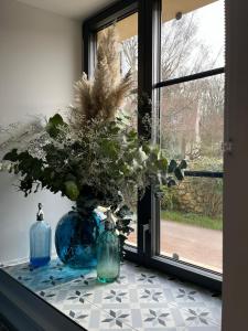 a blue vase sitting on a window sill with a plant at Aux Quatre Petits clos in Jouars-Pontchartrain