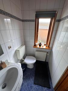 Un baño con inodoro, lavabo y ventana. en Apartment Holzhaus, en Cuxhaven 4 fotos más