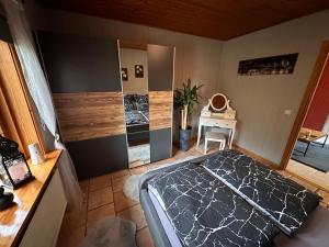 Un dormitorio con una cama grande y un escritorio. en Apartment Holzhaus, en Cuxhaven