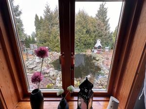 uma janela com dois vasos e flores no parapeito da janela em Apartment Holzhaus em Cuxhaven