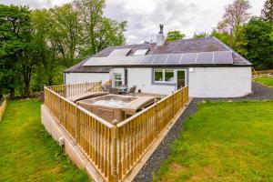 a house with a deck with a sink in front of it at Glen Cottage in Cray