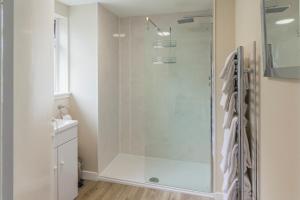 baño con ducha y puerta de cristal en Glen Cottage en Cray