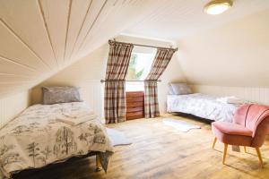 a bedroom with a bed and a chair in a attic at Glen Cottage in Cray