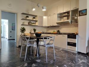 a kitchen with white cabinets and a table and chairs at Casa Stella in Viareggio +26 photos