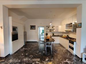 a kitchen with white cabinets and a table in it at Casa Stella in Viareggio