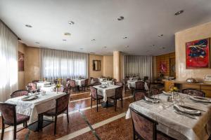 un restaurante con mesas y sillas en una habitación en Hotel Drago, en Mezzocorona