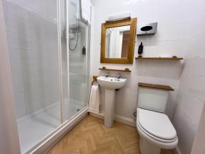 La salle de bains est pourvue de toilettes, d'un lavabo et d'une douche. dans l'établissement The Exchange Hotel, à Brigg