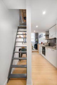 uma escada que leva a uma cozinha com armários brancos em Croix Rousse-Duplex de charme em Lyon