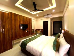 um quarto com uma cama grande e uma ventoinha de tecto em The Grand Sarovar Inn And Suites em Chākan