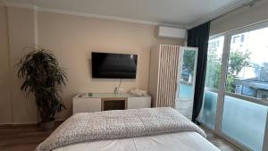 1 dormitorio con 1 cama y TV de pantalla plana en Athens Tales Residence Syntagma Athens, en Atenas
