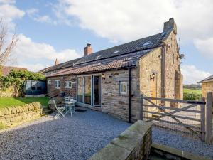 an old stone cottage with a table in front of it at 3 Bed in Bedale 81375 in Hackforth