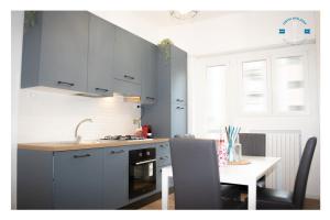 a kitchen with blue cabinets and a table with a sink at La Dolce Sosta Executive in Lido di Ostia