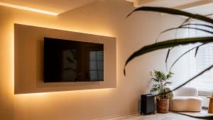 a living room with a flat screen tv on a wall at Stadsappartement Franeker 9 in Franeker
