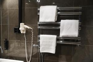 bagno con asciugamani e telefono appeso a una parete di Vimmerby Stadshotell, WorldHotels Crafted a Vimmerby