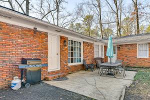 a brick house with a patio with a table and an umbrella at Spacious Starkville Home 4 Mi to MSU Campus in Starkville