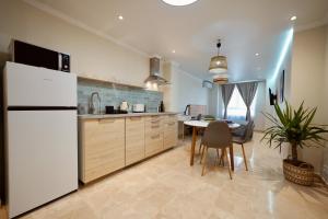 a kitchen with a white refrigerator and a table at Parsami Suites in Santa Pola