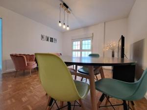 a dining room with a table and green chairs at CASA SÁDABA in Avila