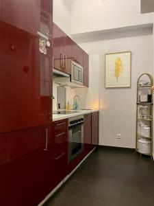 uma cozinha com armários vermelhos e um forno com placa de fogão em Feel at home - Self Check In em Viena