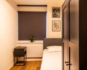 niewielka sypialnia z łóżkiem i oknem w obiekcie Stadsappartement Franeker 11 w mieście Franeker