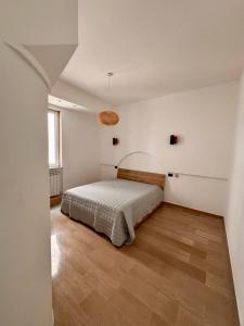 Schlafzimmer mit einem Bett und Holzboden in der Unterkunft Live and Love Italy in Monopoli