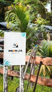 ein Schild auf einem Zaun mit einem Schild drauf in der Unterkunft Pronoia Casa de Playa in Mahahual
