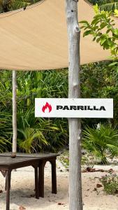 a sign on a tree next to a bench at Pronoia Casa de Playa in Mahahual