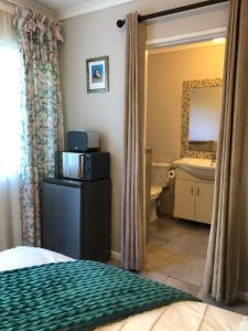 1 dormitorio con cama, lavabo y espejo en Self Catering Guest House, en Ciudad del Cabo