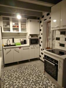 布科的住宿－karine，厨房配有白色橱柜和黑白瓷砖地板。