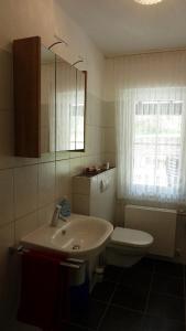 baño con lavabo y aseo y ventana en Fuchs, en Eslohe