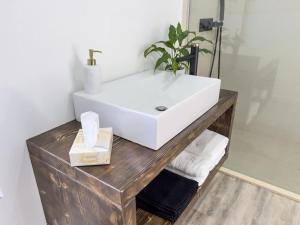 ein Badezimmer mit einem weißen Waschbecken auf einem Holztisch in der Unterkunft Blue Horizon Luxury Villa in Senhora do Rosário