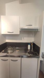 une petite cuisine avec un évier et une cuisinière dans l'établissement Appartements avec balcon au coeur des Chartrons, à Bordeaux 20 autres photos
