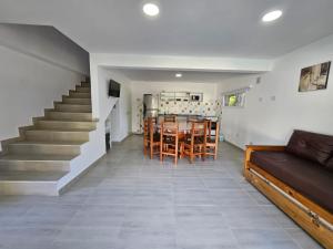 a living room with a staircase and a table and chairs at La mansa del pinar in La Lucila del Mar