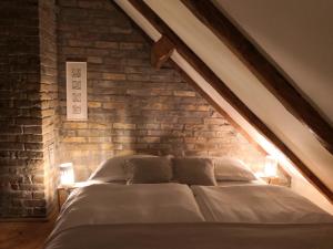 Bett in einem Zimmer mit Ziegelwand in der Unterkunft House of LoVra in Kneževi Vinogradi