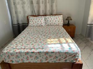 a bed with a floral comforter on it in a bedroom at Appartement Hematiet in Paramaribo