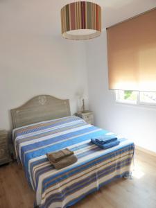 1 dormitorio con 1 cama con 2 toallas en Mont-Roig Apartment, en Cambrils