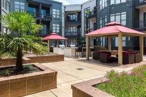 a patio with tables and umbrellas in front of a building at Spacious 2BD with Private Balcony and Free Parking in Charlotte