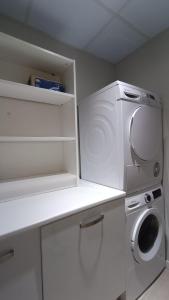 a white kitchen with a washer and a washing machine at LC Plaza del Pilar in Zaragoza
