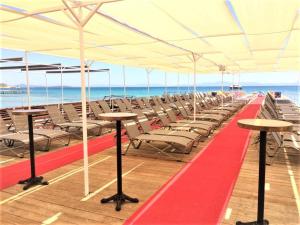 una fila di sedie e tavoli sotto una tenda sulla spiaggia di The Lea Hotel a Didim