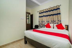 een slaapkamer met een groot bed met rode kussens bij 28119 Omkar Global Inn in Bangalore