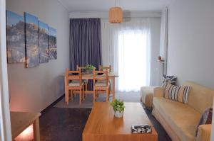 een woonkamer met een bank en een tafel bij Modern 2 BR apartment near Acropolis in the heart of the city - Explore Center by foot in Athene