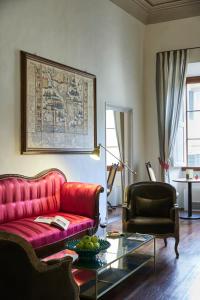 a living room with a red couch and a glass table at Peruzzi Urban Residences in Florence
