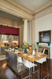 una cocina con una gran mesa de madera y sillas blancas. en Peruzzi Urban Residences, en Florencia