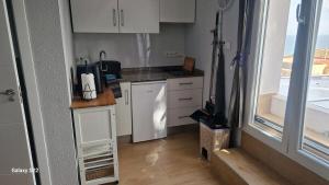 a small kitchen with white cabinets and a window at Beach Life Carabassi Beach Gran Alacant in Gran Alacant