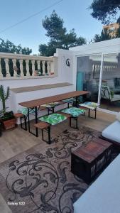 un patio con mesa y bancos sobre una alfombra en Beach Life Carabassi Beach Gran Alacant, en Gran Alacant
