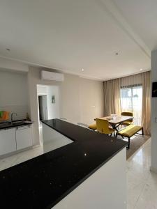 拉馬薩的住宿－luxueux duplex avec Rooftop a la Marsa，厨房以及带黑色台面的起居室。