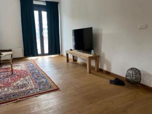 a living room with a flat screen tv and a table at Spacious app Diamond center #201 in Antwerp