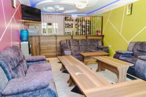 a waiting room with couches and a table and a tv at Gerly Homes in Kakamega