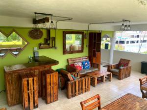 una sala de estar con muebles de madera y paredes verdes. en Private Rooms-Art Punta Cana en Punta Cana