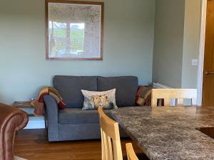 a living room with a couch and a table at The Byre @ Cow Close - Stay, Rest and Play in the Dales. in Leyburn