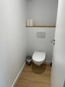 a bathroom with a white toilet and a wooden floor at Samui - Equipé borne de recharge - Powering Station Electric Car in Capbreton +13 photos